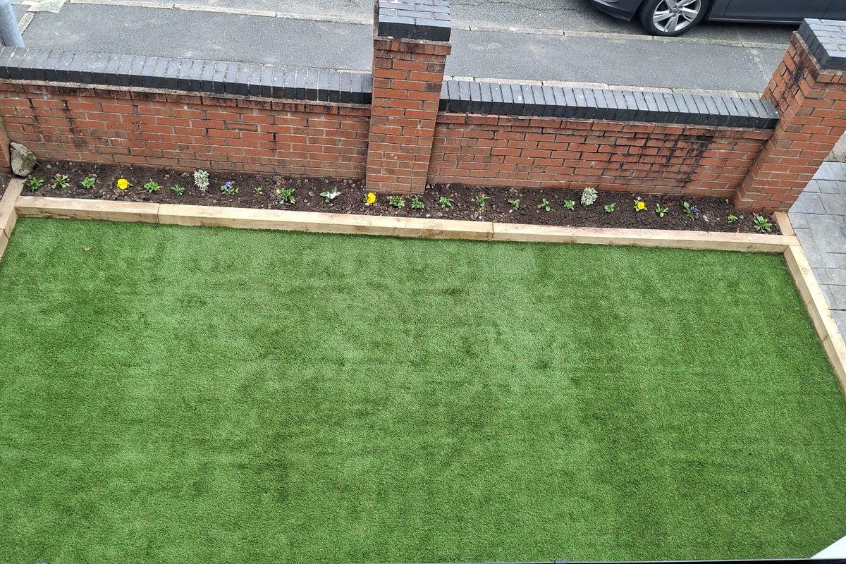 Front garden after: artificial lawn with railway-sleeper edging and a newly planted border